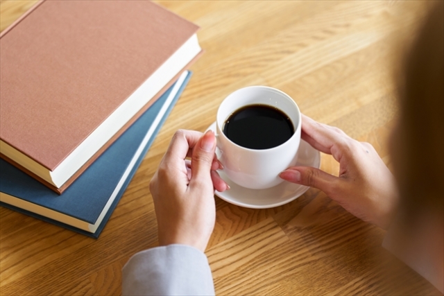 読書をしながらコーヒーを飲む女性