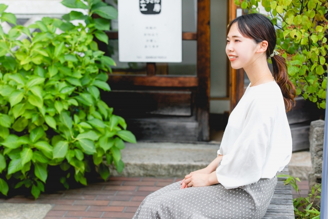 カフェのベンチに座る女