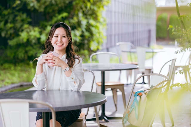 カフェのテラス席でスムージーを飲む女性