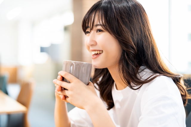 コーヒーを飲んで笑顔の女性