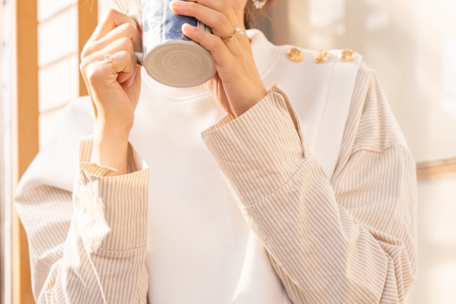 家でホットコーヒーを飲む女性
