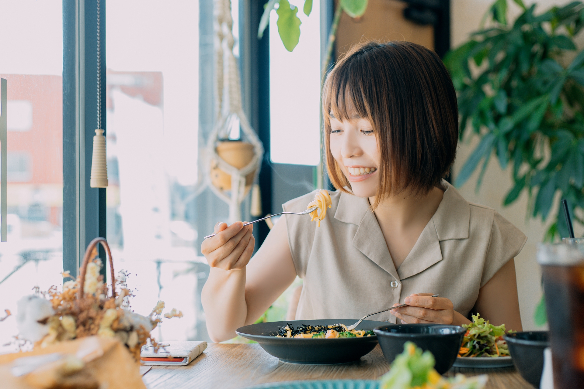 カフェでパスタを食べる女性