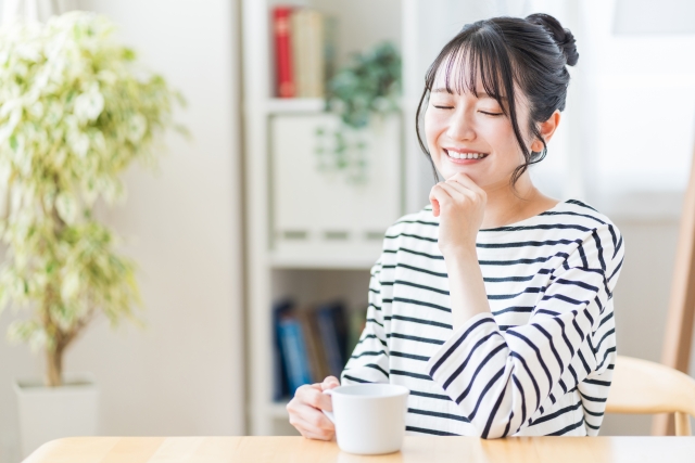 リビングでコーヒーを飲んでいる若い女性。