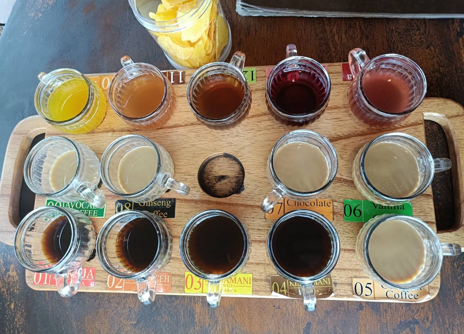 木のトレーに並んだバリ島のコーヒー飲み比べセット。番号ラベル付きのグラスが14杯